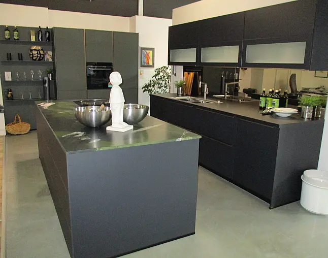 Moderne schwarze Küche mit Insel, integrierten Geräten und dekorativer Statue auf Arbeitsplatte.