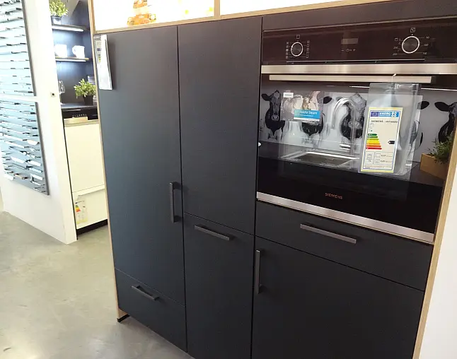 Moderne schwarze Küchenschränke mit eingebautem Siemens-Backofen und Griffen.