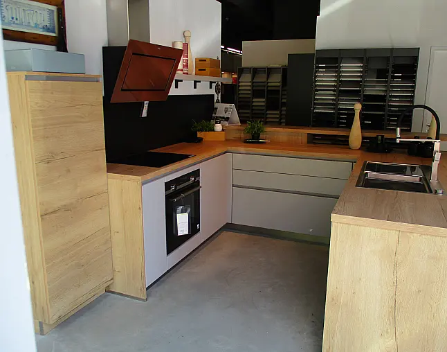 Moderne Küche mit holzfarbenen Fronten, grauen Schränken, Kochfeld, Ofen und Spüle.