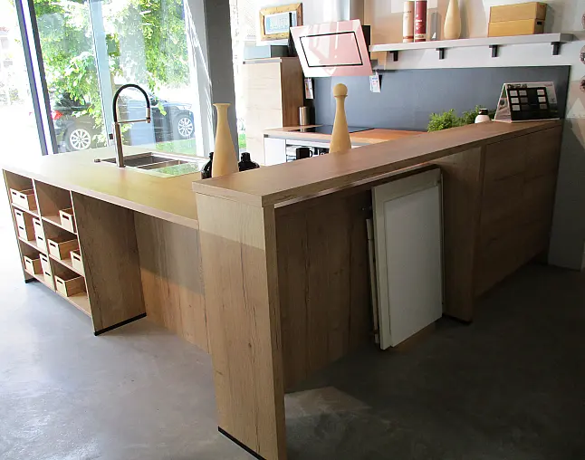 Moderne Küche mit grauen Flächen, Holztheke, Spülbecken und offenem Regal mit Fächern.