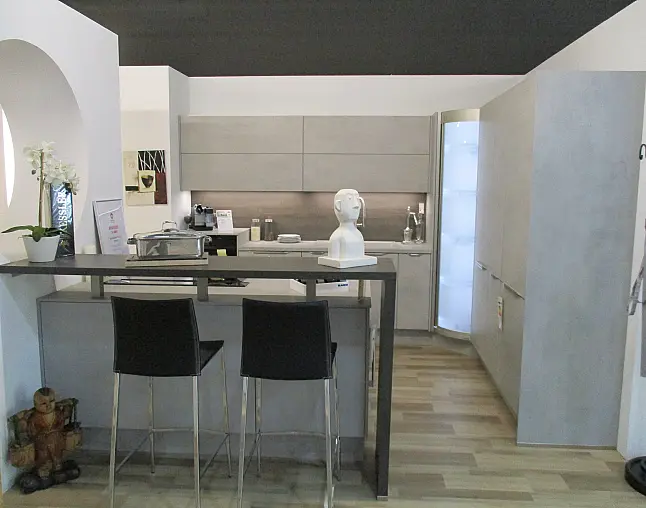 Moderne Küche mit grauen Schränken, Kochinsel, Barhockern und Dekoration mit einer weißen Skulptur.